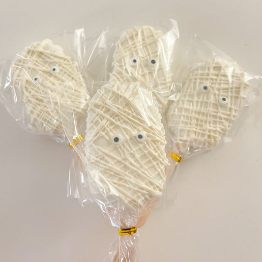 Handmade Halloween mummy cakesicles decorated with white chocolate and spooky candy eyes.
Halloween mummy cakesicles with chocolate coating and cute mummy faces on dessert sticks.
A dozen handcrafted Halloween mummy cakesicles individually wrapped for parties and gifts.
Chocolate-covered Halloween mummy cakesicles with edible decorations for Halloween celebrations.
Spooky Halloween mummy cakesicles displayed as festive party treats.
Handmade mummy cakesicles with white chocolate drizzle and candy eyes for H